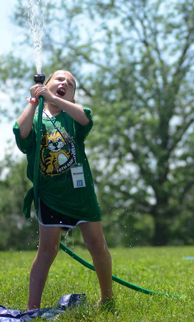 Oniah Heater, 8, commandeers the hose during a water kickball game